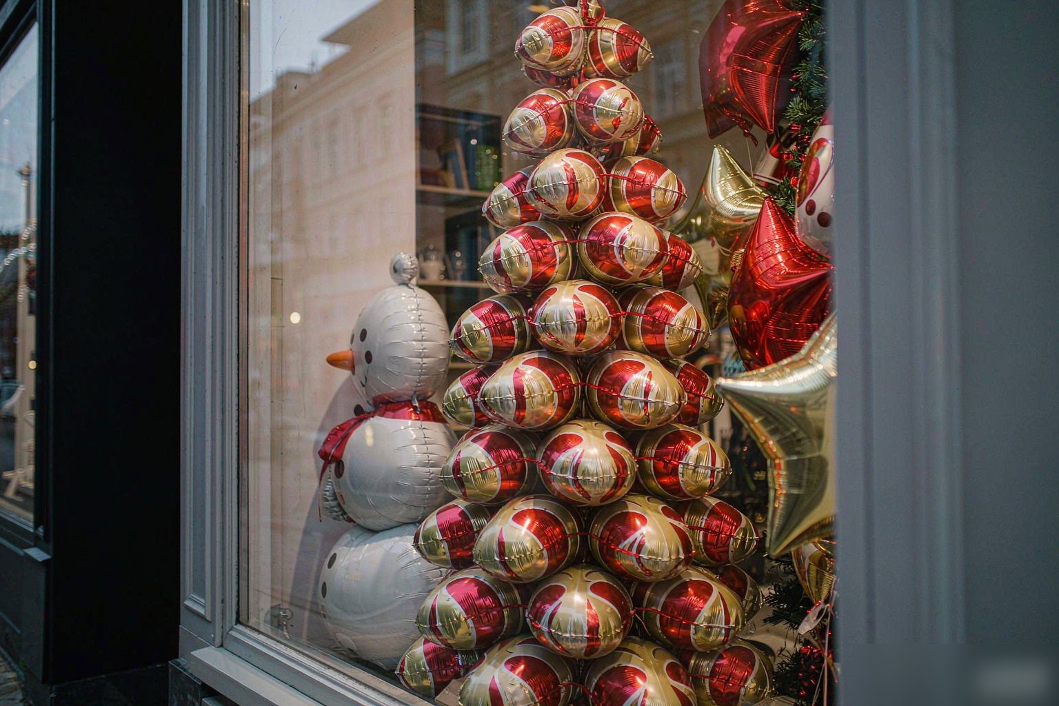 Christmas shop window display built with foil balloons and a garland